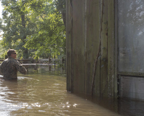 West Orange, Texas - WEST ORANGE, Texas – U.S. Marine Corps Sgt. Austin Rusk a reconnaissance Marine team leader with Charlie Company, 4th Reconnaissance Battalion, 4th Marine Division, Marine Forces Reserve, wades through waist deep flood water in order to get to a second story door to complete an emergency rescue call in West Orange, Texas, Sept. 1, 2017. Marine Corps Reserve forces are supporting FEMA and state and local officials, focused on life-saving efforts and resupply missions in the aftermath of Hurricane Harvey. (U.S. Marine Corps photo by Pfc. Samantha Schwoch/Released)